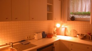 A kitchen with a sink, toaster, kettle, and a window with a view of greenery. - Your vacation home between forest and waves (Kellenhusen)