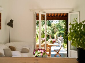 A room with a white sofa, a floor lamp, a wooden table, and a potted plant. - Holiday Home in Frejus Near Sea and Lake (Fréjus)
