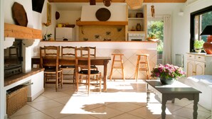 A kitchen with wooden beams, a dining area with chairs, a table, and a window with a view. - Holiday Home in Frejus Near Sea and Lake (Fréjus)