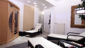 A spa room with a massage chair, a wooden cabinet, and a mirror on the wall. - Relaxing Apartment With Sauna (Ruhmannsfelden)