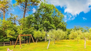 A grassy outdoor area with a wooden swing set and a bench. - Rustic Farmhouse in Terricciola (Terricciola)