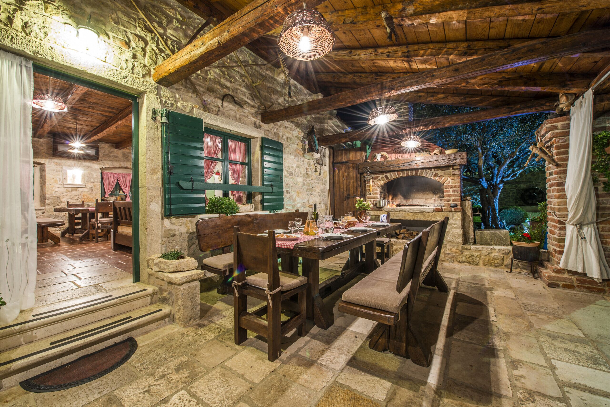 Ein rustikales Stein-Interieur mit Kamin aus Stein, Holzmöbeln und Steinböden.