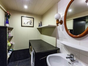 A bathroom with a sink, mirror, and shelves with toiletries. - Appealing Chalet in Westouter With Garden (Heuvelland)