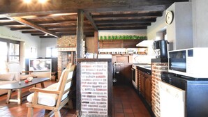 Una cucina rustica con travi in legno a vista, un muro in mattoni e un forno a microonde moderno.