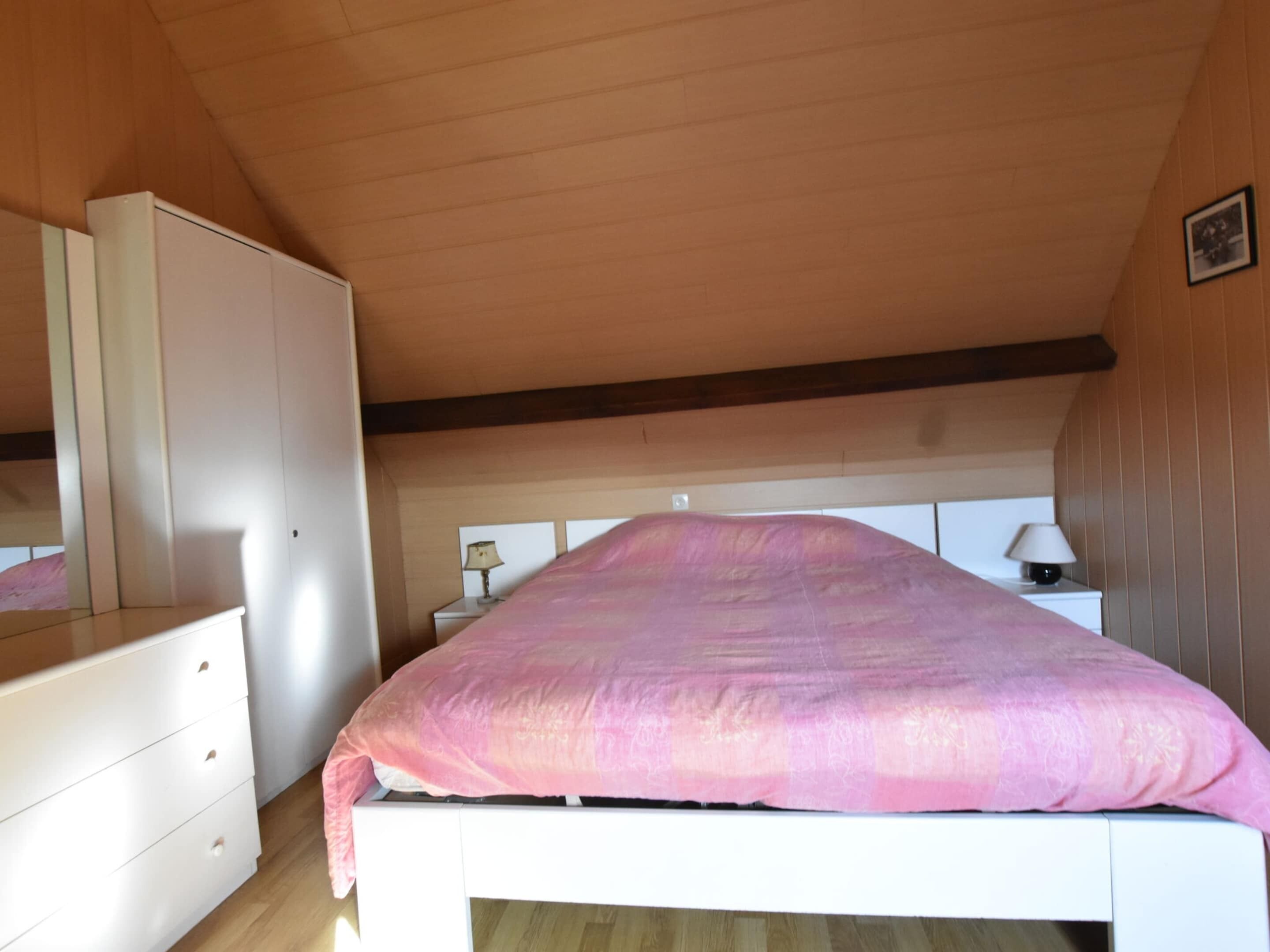 Ein Schlafzimmer mit einem Bett, einem Schminktisch, einem Nachttisch und einer Lampe.