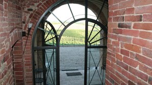 A brick archway leading to a terrace with a view of a vineyard. - Belvilla by OYO Tulipano (Montepulciano)