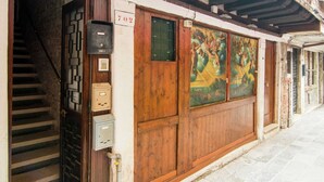 A building with a wooden facade, a staircase leading to an upper level, and a mural on the wall. - Belvilla by OYO Paradiso (Venice)