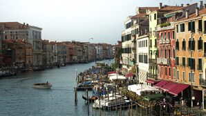 A canal lined with historic buildings, gondolas docked at the edge, and a clear view of the waterway. - Belvilla by OYO Paradiso (Venice)