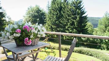 Enjoy a serene outdoor space with a table, bench, and beautiful views of the surrounding landscape.