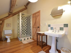 A bathroom with a glass shower, wooden door, and a sink with a mirror. - Castle Wing Situated in the Heart of a Quiet (Manhay)