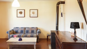 Een woonkamer met een bank, een salontafel, een lamp en een open haard.