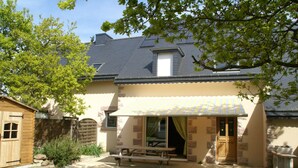 A house with a patio, a wooden shed, and a stone wall. - Cozy Garden Home in Erquy (Erquy)