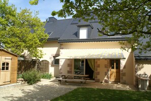 A house with a patio, a wooden shed, and a stone wall. - Cozy Garden Home in Erquy (Erquy)