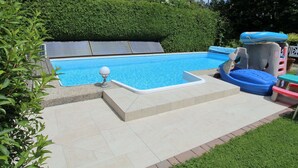 A swimming pool with a slide and a small inflatable pool. - Apartment in Wernberg in Carinthia With Pool (Wernberg)