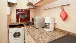 A compact kitchen with a washing machine, a microwave, a toaster, and a coffee maker. - Apartment in Florence Near Duomo (Florence)