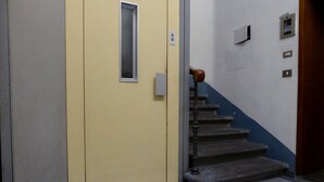A staircase with a checkered floor leading to a door with a small window. - Apartment in Florence Near Duomo (Florence)
