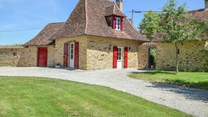 A stone house with a red-tiled roof, a gravel driveway, and a grassy lawn. - Dreamscape: Rustic Elegance (Saint-Medard-d'Excideuil)