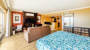 A hotel room with a bed, a sofa, a desk, and a television.