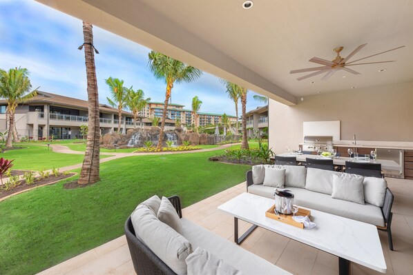 A modern outdoor patio with a sofa, a dining table, and a ceiling fan. - KLVR presents Honua Kai Resort, Luana Villas 11A&C (Lahaina)