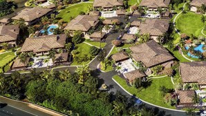 Een resort met meerdere bungalowgebouwen, een centraal gelegen zwembad en verzorgde gazons.