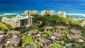 A resort with multiple bungalow-style buildings, a central pool, and ocean views.