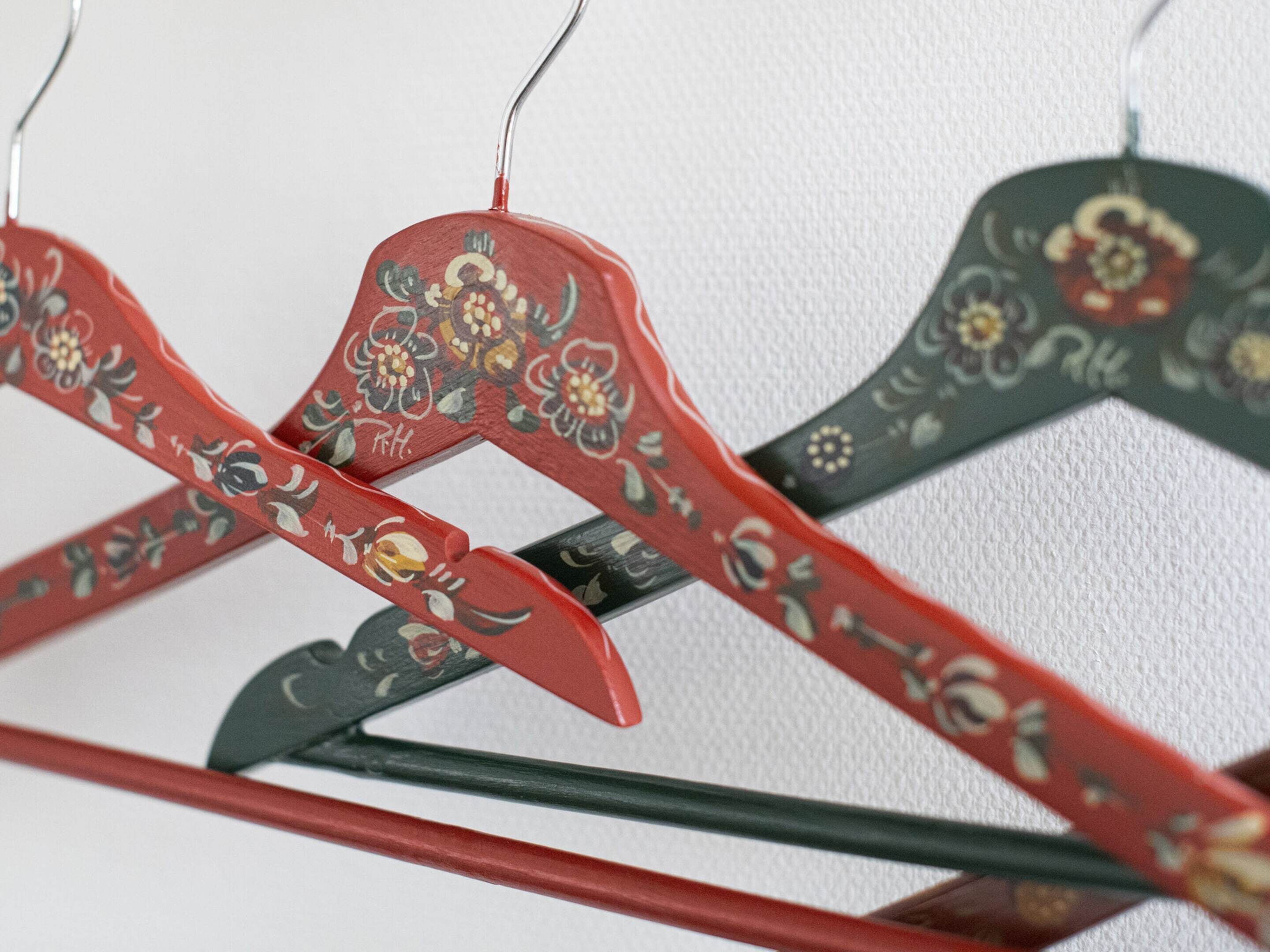 A row of wooden hangers with floral designs.