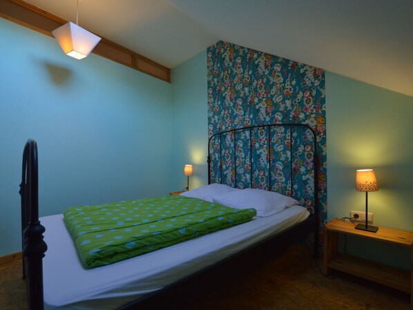 A bedroom with a bed, two bedside lamps, a floral-patterned headboard, and a wooden nightstand. - Gorgeous Holiday Home in Ovifat With Sauna (Waimes)