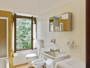 A bathroom with a toilet, bidet, sink, and a mirror. - Unique Holiday Experience in Greenery near Lake (Verbania)