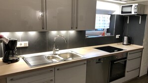 Una cocina moderna con electrodomésticos de acero inoxidable, un lavamanos doble y un horno empotrado.