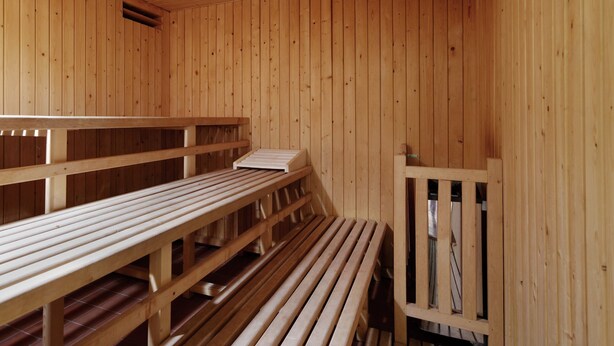 Un sauna avec des bancs en bois et une banquette.