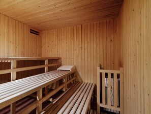 A sauna with wooden benches and a bench seat. - Forest Getaway in Berlin (Spreehagen)