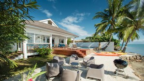 A beachfront property with a pool, outdoor seating, and a barbecue area. - Villa TEPOE,  accès direct au lagon avec piscine et plage (Moorea-Maiao)
