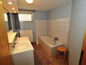 A bathroom with two sinks, a bathtub, a window, and a radiator. - Chalet in Ardennes Near Forest Trails (Malmedy)
