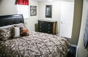 A bedroom with a bed, dresser, and door. - Comfy Lovelock Home Near Freeway (Lovelock)