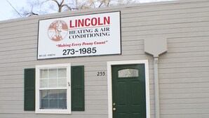 Un bâtiment sur lequel est apposée une enseigne indiquant « Lincoln Heating & Air Conditioning », avec un logo, un numéro de téléphone et le texte « Chaque centime compte ».
