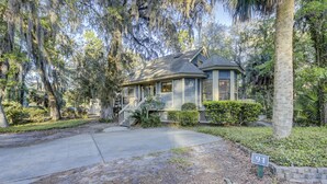 A two-story house with a front porch, a driveway, and a mailbox marked with the number 91. - Sunset Rentals | Kingston Dunes 91 | Dog Friendly (Hilton Head Island)
