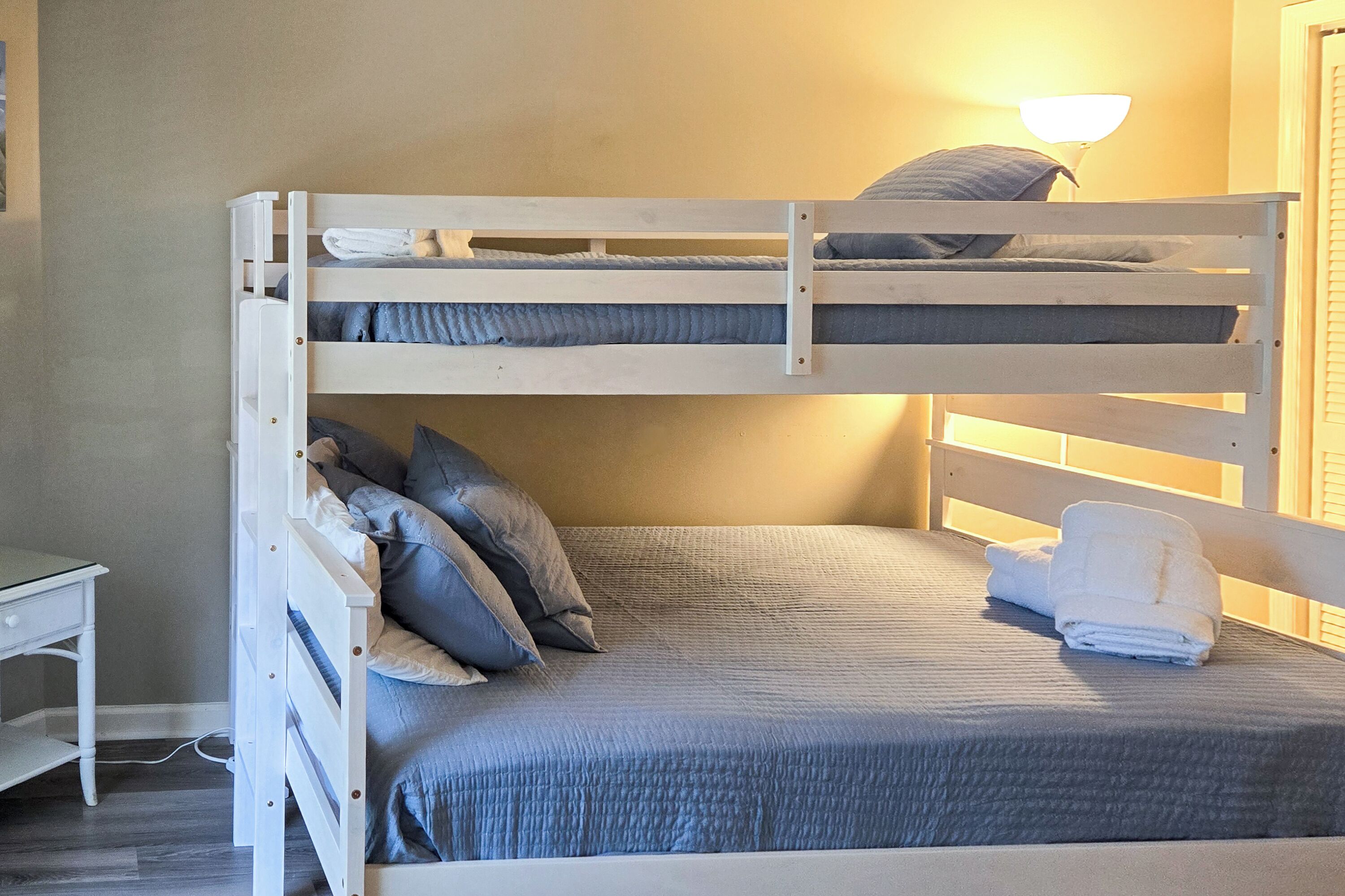 Un lit superposé avec un bureau et une lampe, caractérisé par un design simple et épuré.