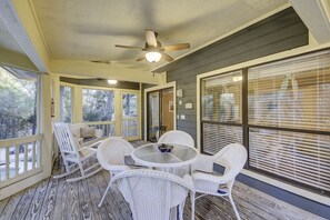 Relax in a serene outdoor space with a round table and comfortable wicker chairs, surrounded by expansive views.
