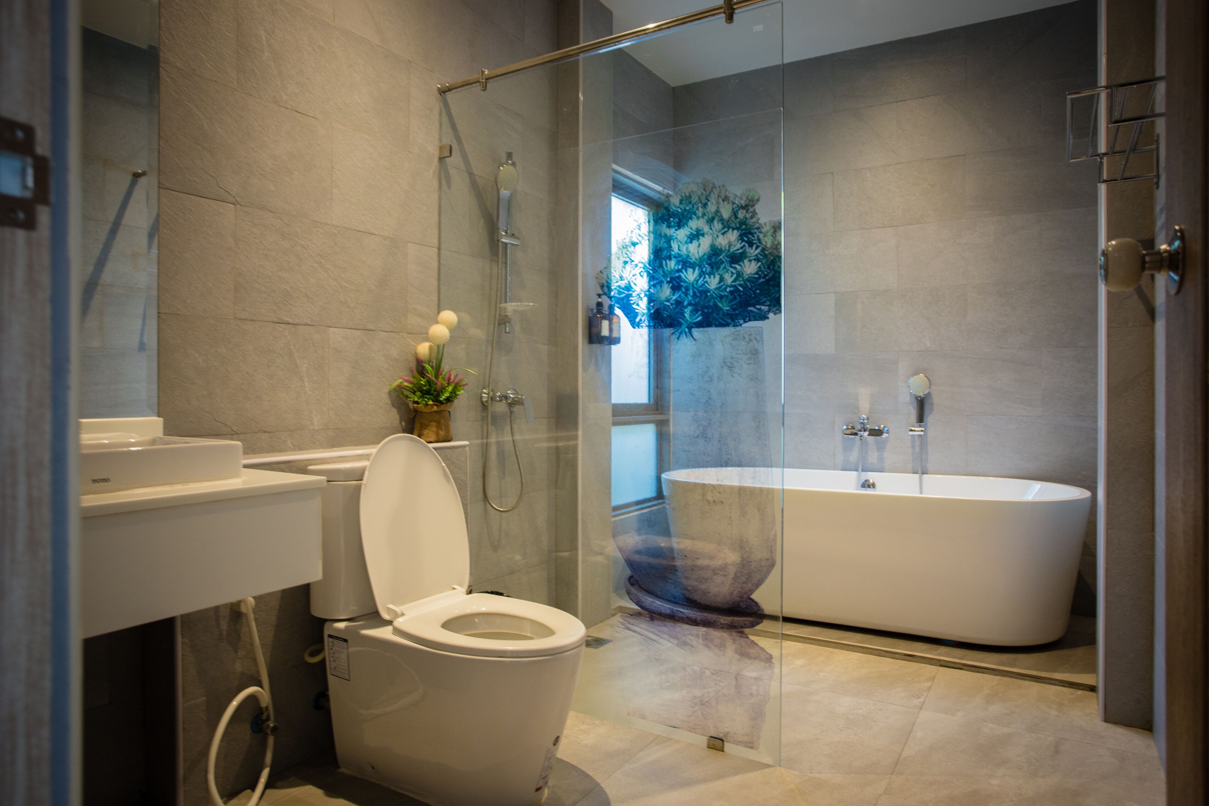 Une salle de bain moderne équipée de toilettes, d’un lavabo et d’une baignoire sur pieds.