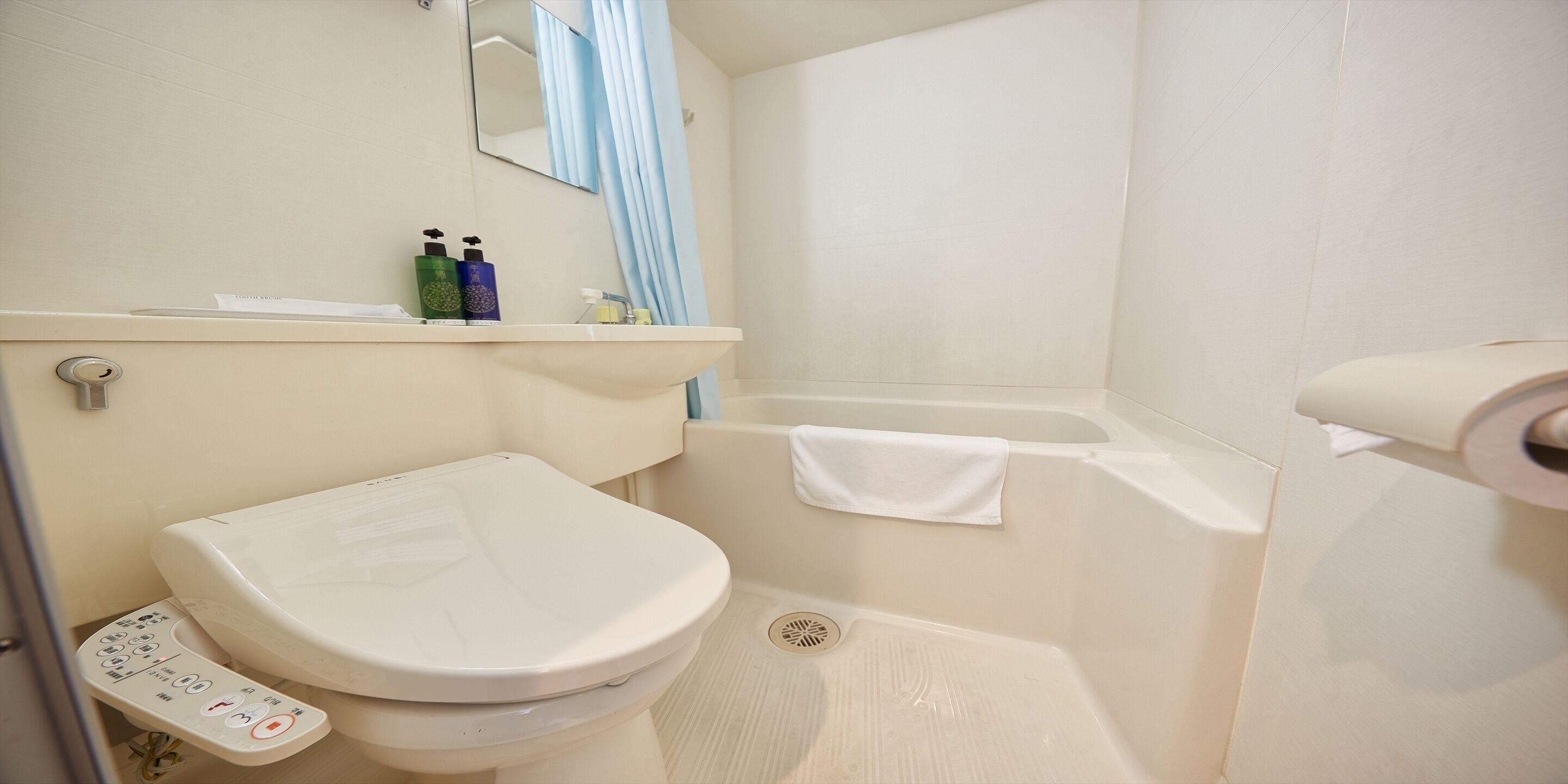 Een badkamer met toilet, wastafel, spiegel en bad.