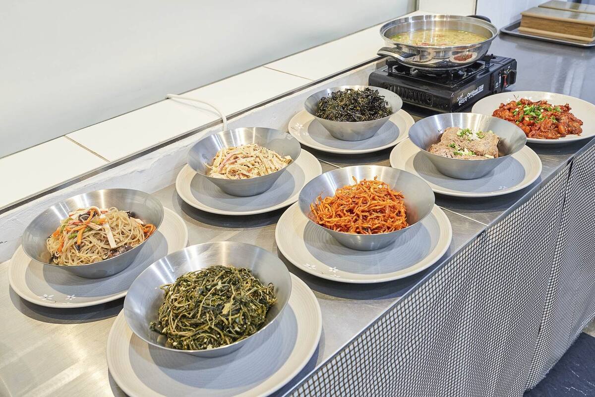 A buffet table with various dishes in bowls.