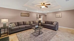 A living room with two sofas, a coffee table, and a ceiling fan. - *Reduced Pricing* Spacious Disney Vacation w/ Game Room (Orange)