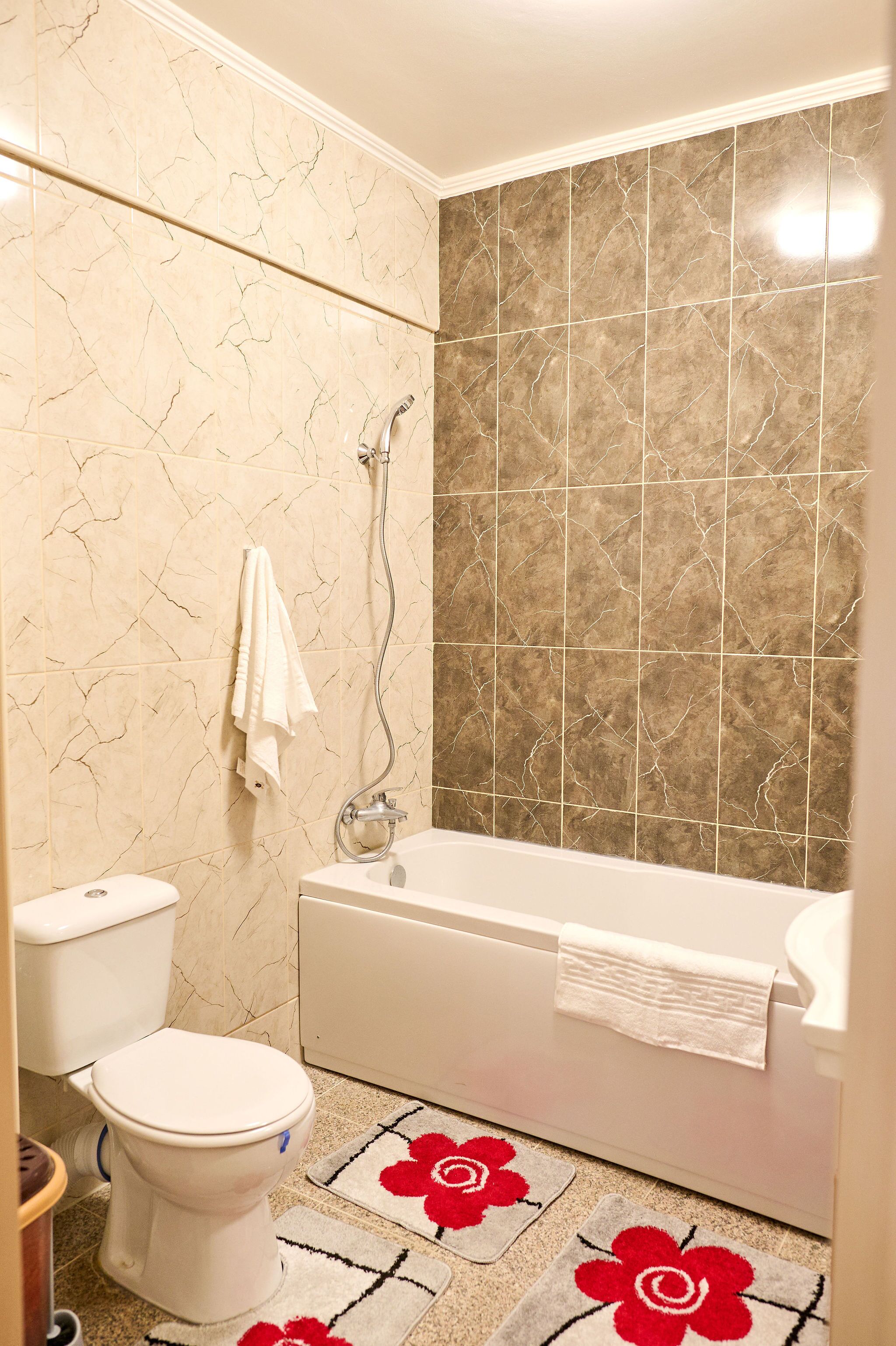 Ein Badezimmer mit Toilette, Badewanne und Dusche.