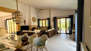 Una cocina amplia con comedor, que incluye una mesa de vidrio, sillas modernas y una lámpara colgante.
