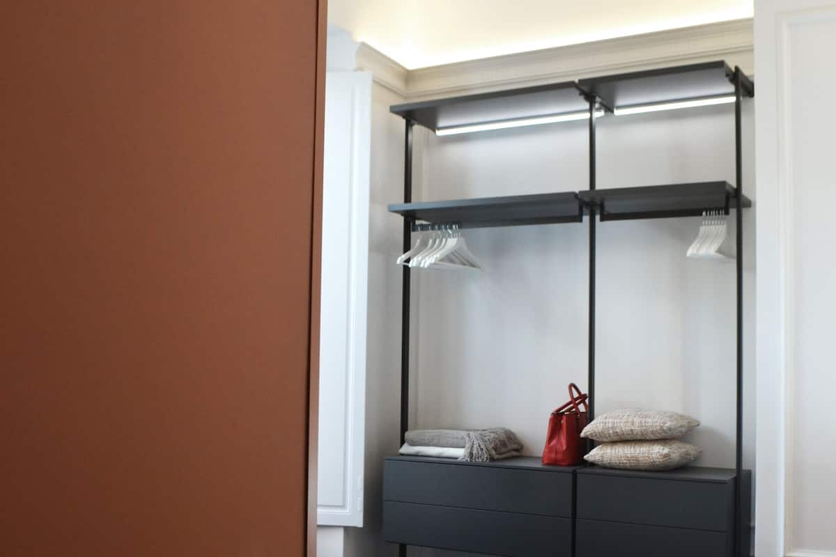 Un dormitorio con cama, armario y ventana.