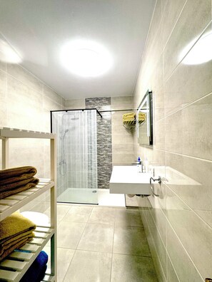 Bathtub, hair dryer, towels, toilet paper