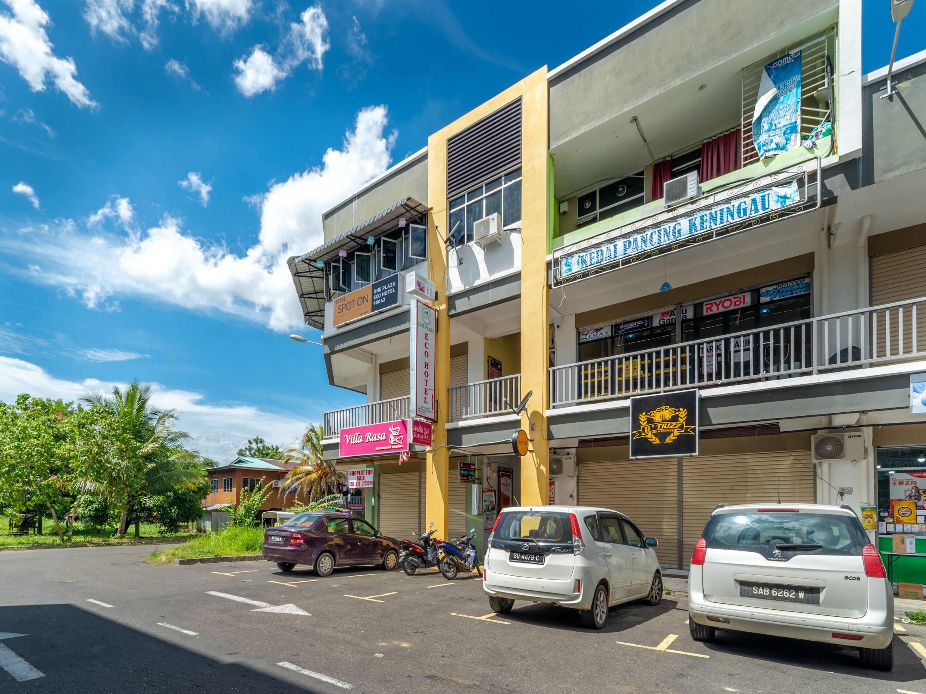 A multi-story building with various shops and businesses on the ground floor, including a hotel and a restaurant.