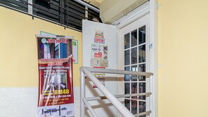 A hotel entrance with a staircase, a poster advertising the Eco Hotel, and a sign indicating the price per night. - SPOT ON 90042 One Plaza Eco Hotel (Keningau)