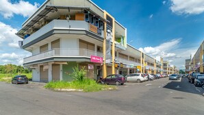 A multi-story hotel with balconies and a parking lot. - SPOT ON 90042 One Plaza Eco Hotel (Keningau)