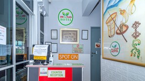 A hotel reception area with a counter, framed welcome sign, and a painting on the wall. - SPOT ON 90042 One Plaza Eco Hotel (Keningau)
